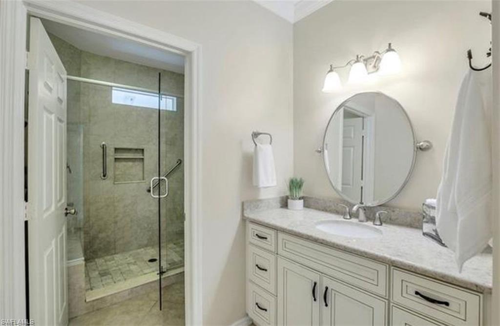 298 Emerald Bay Circle, Unit K6 Naples, FL 34110 - Photo 8 of 9 a bathroom with a double vanity sink and a mirror