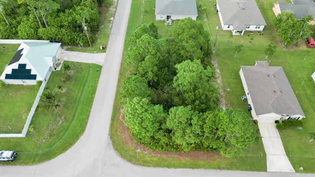 an aerial view of a house with a garden and lake view