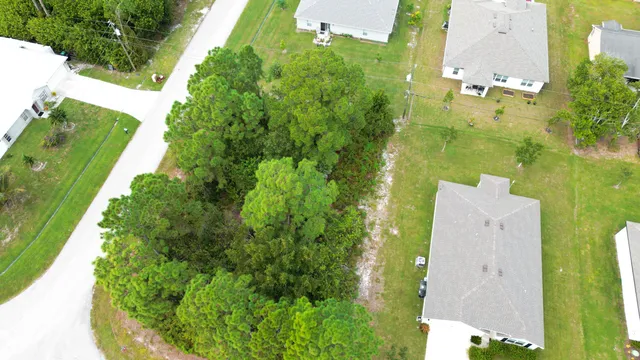 an aerial view of a house with a garden and lots of residential buildings