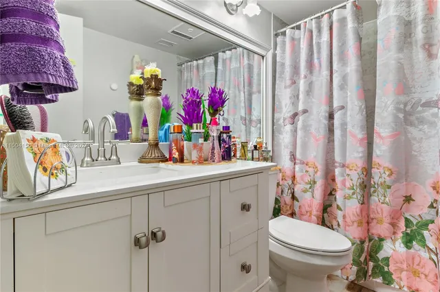 a bathroom with a sink a toilet and shower curtain