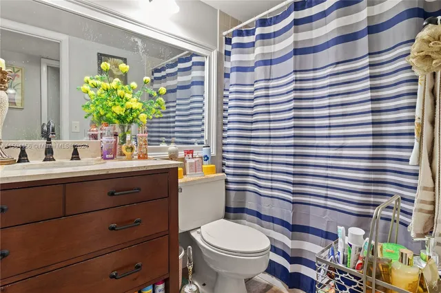 a bathroom with a sink mirror vanity and toilet