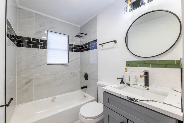 a bathroom with a granite countertop sink toilet and shower