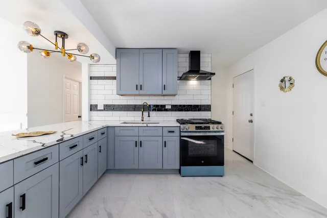 a kitchen with stainless steel appliances granite countertop a sink stove and refrigerator