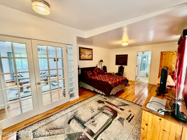 a bedroom with a bed and wooden floor