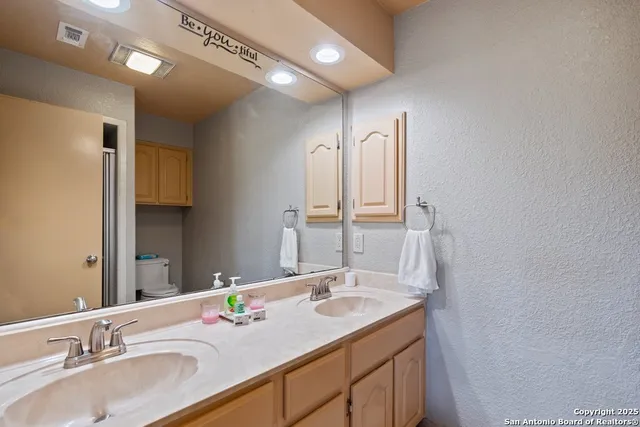 a bathroom with a granite countertop sink and a mirror