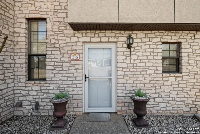 a view of a brick house with potted plants