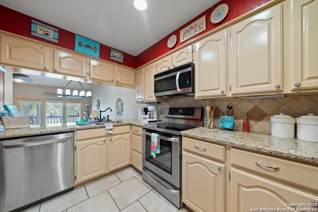 a kitchen with stainless steel appliances granite countertop a sink and cabinets