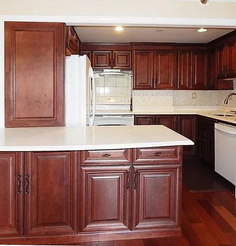 a kitchen with granite countertop wood cabinets stainless steel appliances and a sink