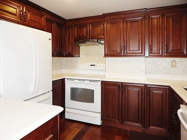 a kitchen with granite countertop wooden cabinets and white appliances