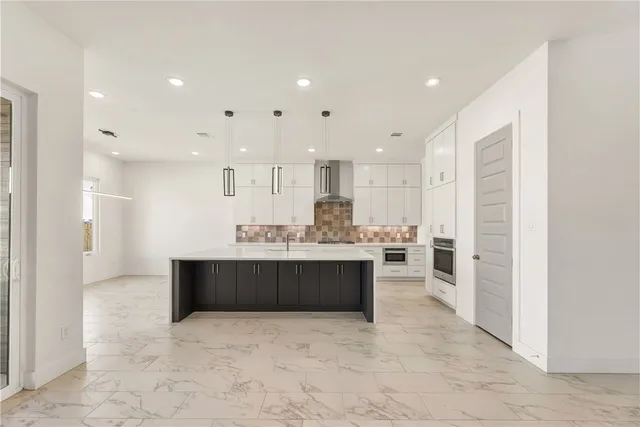 a view of kitchen with kitchen island sink and refrigerator