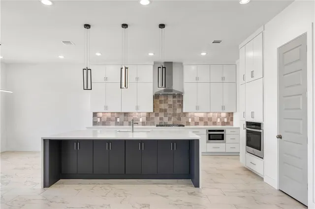 a kitchen with stainless steel appliances kitchen island granite countertop a stove a sink and a refrigerator