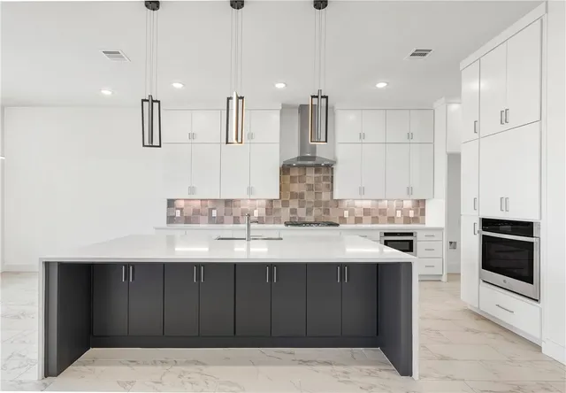 a kitchen with kitchen island white cabinets and stainless steel appliances