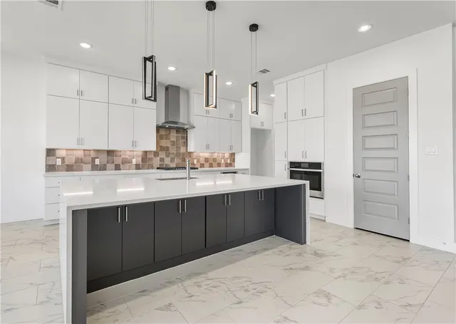 a kitchen with stainless steel appliances kitchen island granite countertop a refrigerator and a sink
