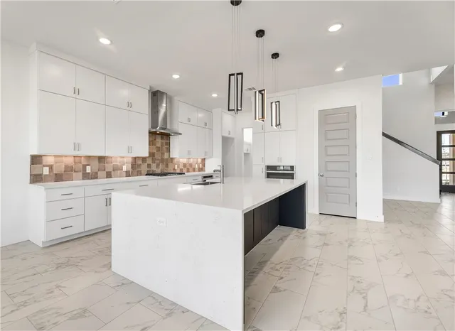 a open kitchen with kitchen island a sink stainless steel appliances and cabinets
