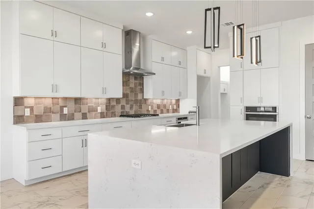 a kitchen with kitchen island granite countertop a sink a stove and cabinets