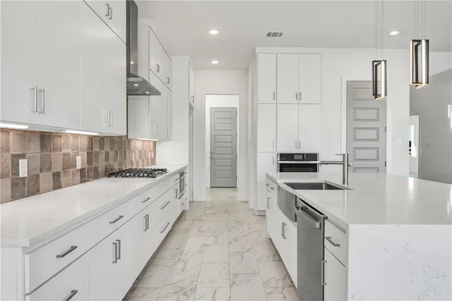 a large kitchen with stainless steel appliances granite countertop a lot of counter space and wooden floors