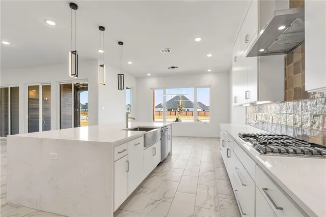 a large kitchen with stainless steel appliances kitchen island a large counter top and a view of living room