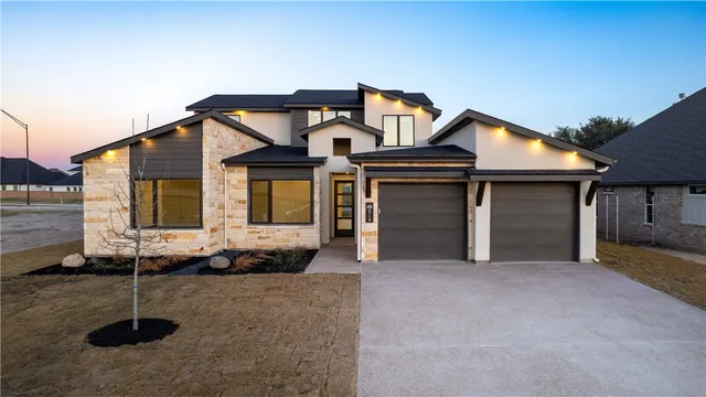 a front view of a house with a garden and plants
