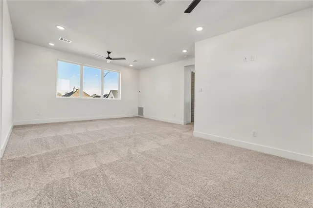 an empty room with a window and a ceiling fan