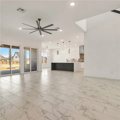 a view of a livingroom with a fireplace a sink and a kitchen space