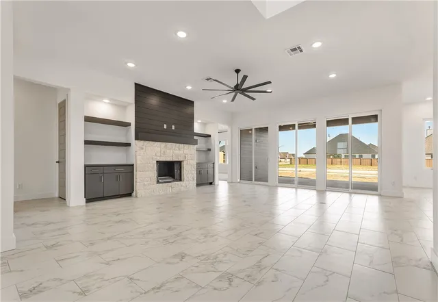 a view of an empty room with a fireplace and a window