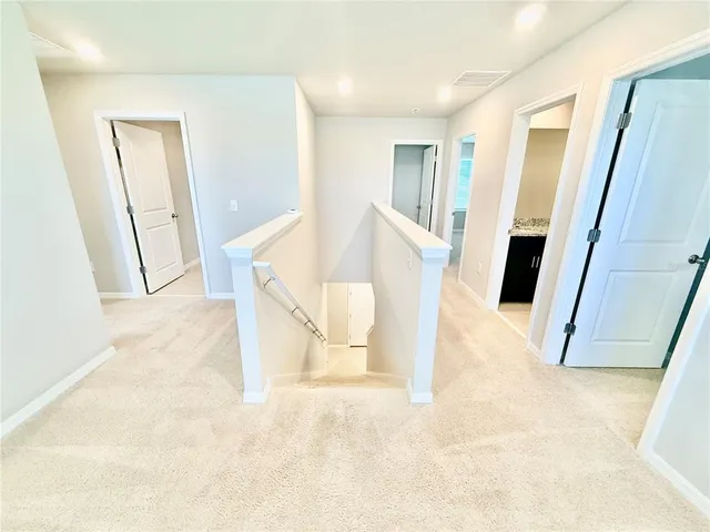 a view of a hallway and closet with wooden floor