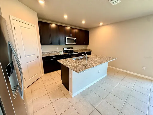 a kitchen with granite countertop wooden cabinets and stainless steel appliances