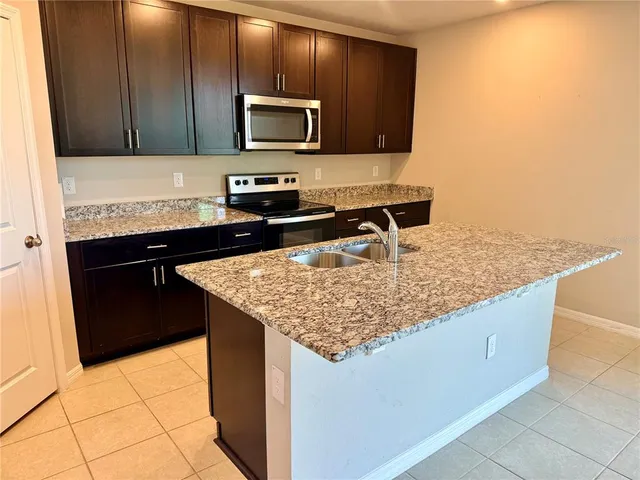 a kitchen with stainless steel appliances granite countertop a sink and a stove