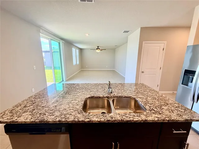 a view of kitchen with granite countertop cabinets and stainless steel appliances