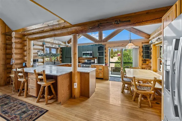 a dining room with wooden floor a table and chairs