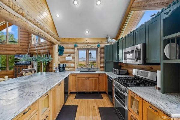 a large kitchen with stainless steel appliances granite countertop a large stove a sink and a dining table