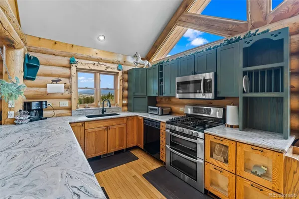 a kitchen with stainless steel appliances granite countertop a stove top oven a sink and dishwasher