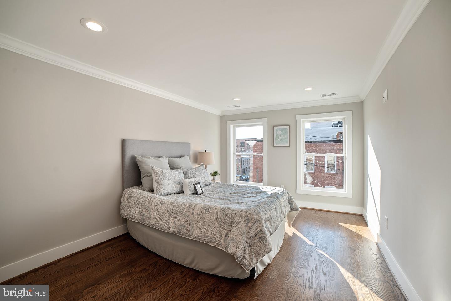 3425 O Donnell Street Baltimore, MD 21224 - Photo 16 of 29 a bedroom with a large bed and wooden floor