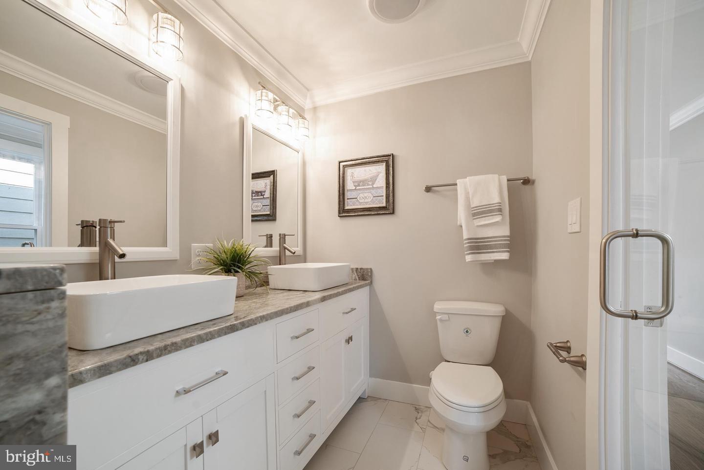 3425 O Donnell Street Baltimore, MD 21224 - Photo 19 of 29 a bathroom with a granite countertop toilet sink and mirror