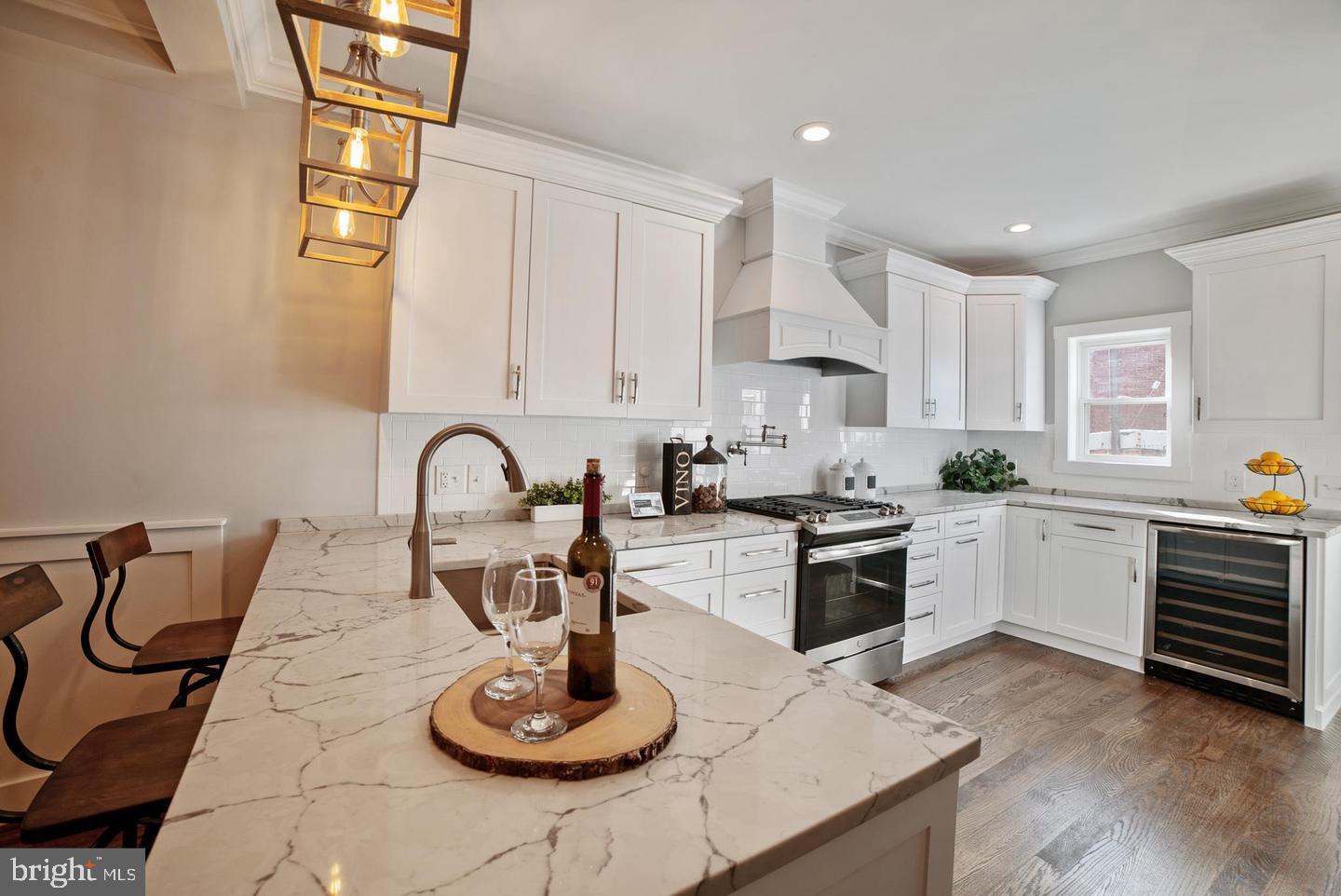 3425 O Donnell Street Baltimore, MD 21224 - Photo 7 of 29 a kitchen with stainless steel appliances granite countertop a sink a stove and white cabinets with wooden floor