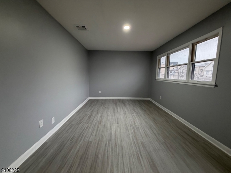 327 Bond Street Elizabeth Port, NJ 07206 - Photo 18 of 22 an empty room with wooden floor and windows