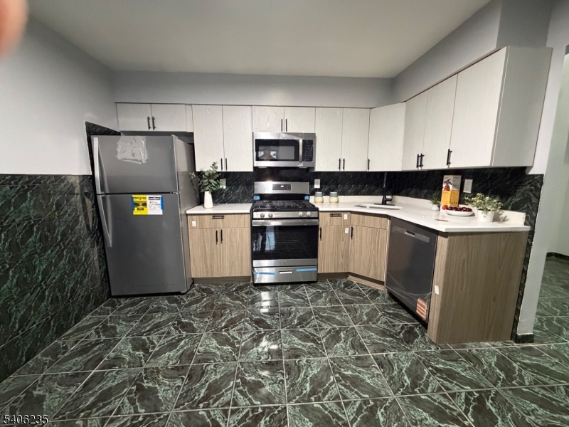 327 Bond Street Elizabeth Port, NJ 07206 - Photo 6 of 22 a kitchen with stainless steel appliances granite countertop a refrigerator sink and stove