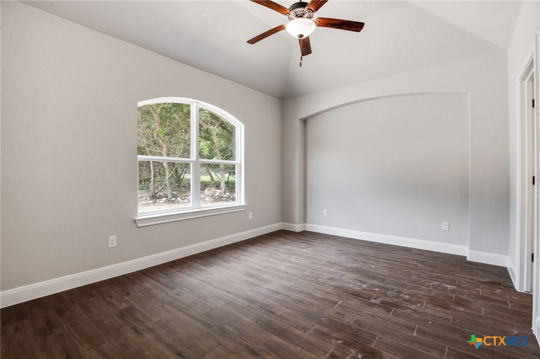 192 Weatherby Drive Spring Branch, TX 78070 - Photo 23 of 24 an empty room with wooden floor chandelier fan and windows