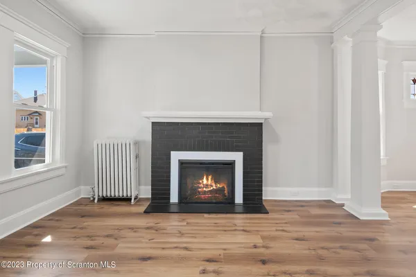 a view of empty room with wooden floor and fireplace