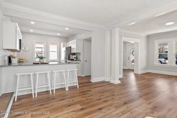 a kitchen with stainless steel appliances granite countertop a sink and a granite counter tops with wooden floors