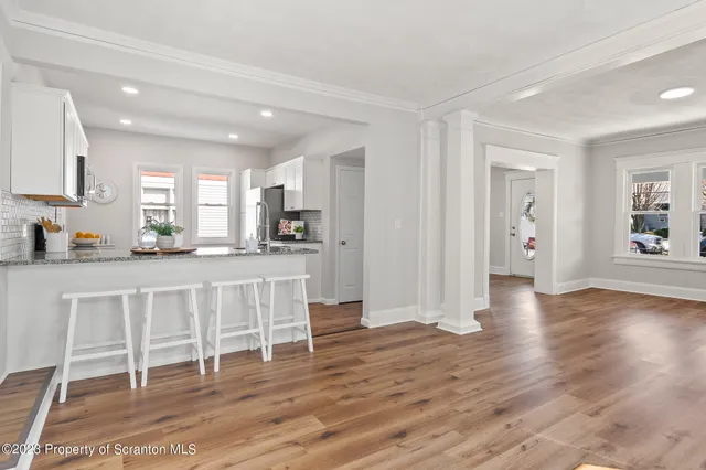 a kitchen with stainless steel appliances granite countertop a sink and a granite counter tops with wooden floors