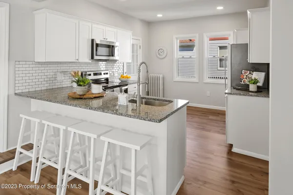 a kitchen with stainless steel appliances a stove microwave and refrigerator