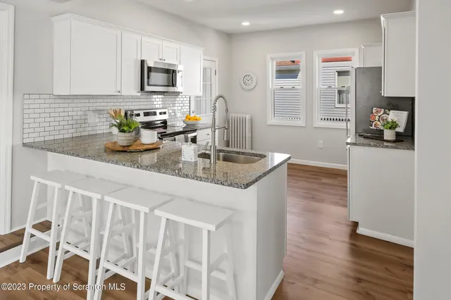 a kitchen with stainless steel appliances a stove microwave and refrigerator
