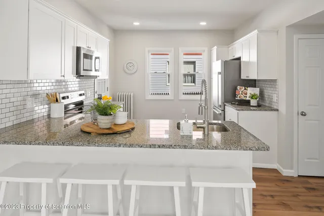 a view of a livingroom with wooden floor and stairs