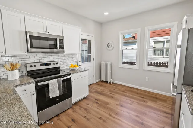 a bathroom with a sink a mirror and a potted plant