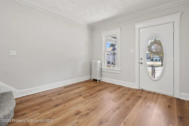a view of entryway and hall with wooden floor