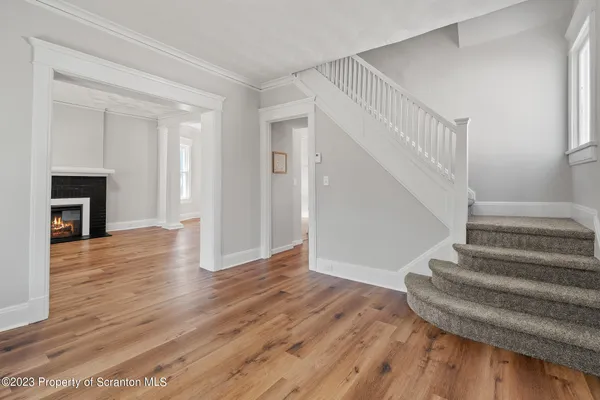 a view of empty room with wooden floor and a window