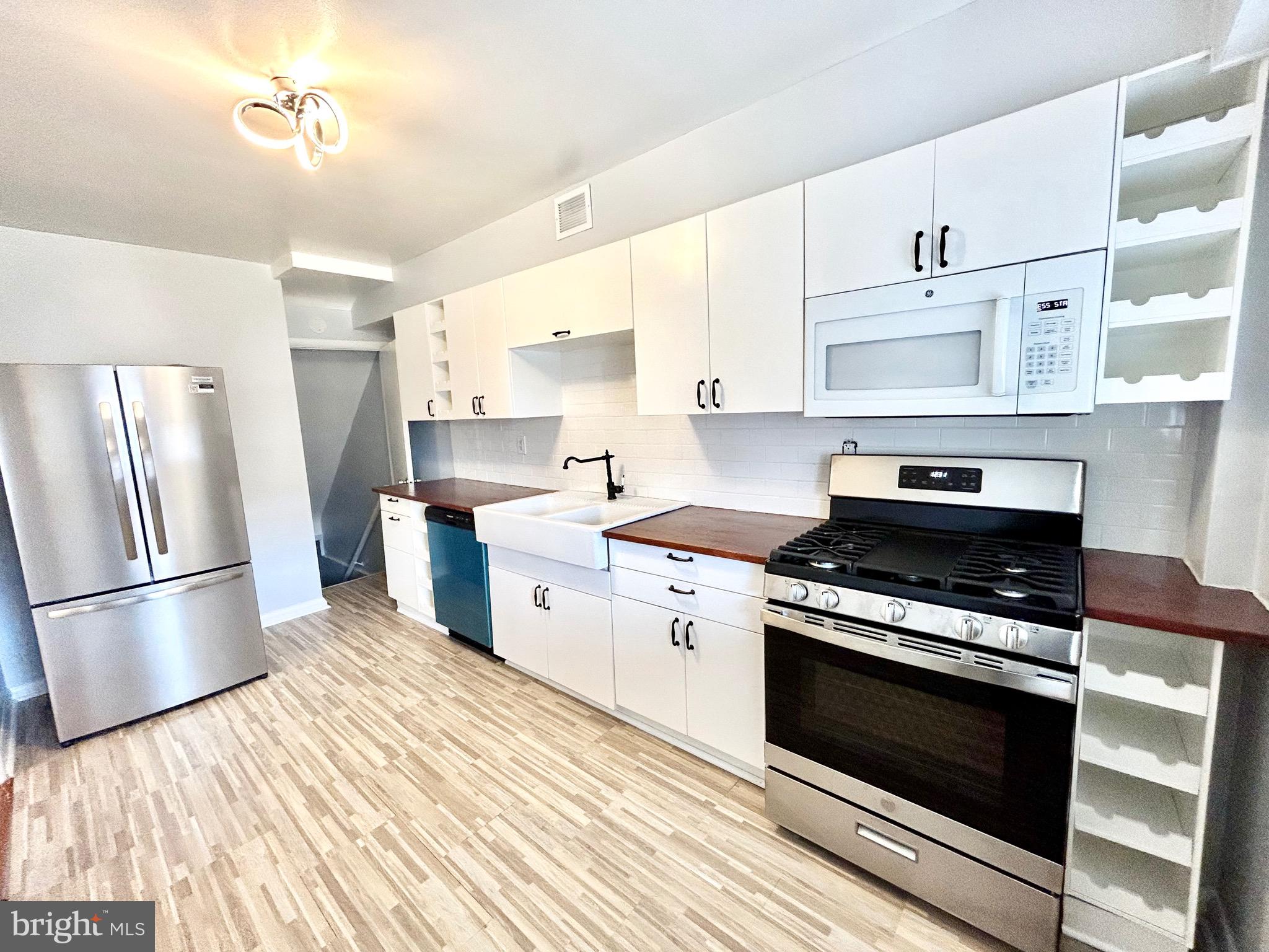 a kitchen with stainless steel appliances a stove a sink and a refrigerator