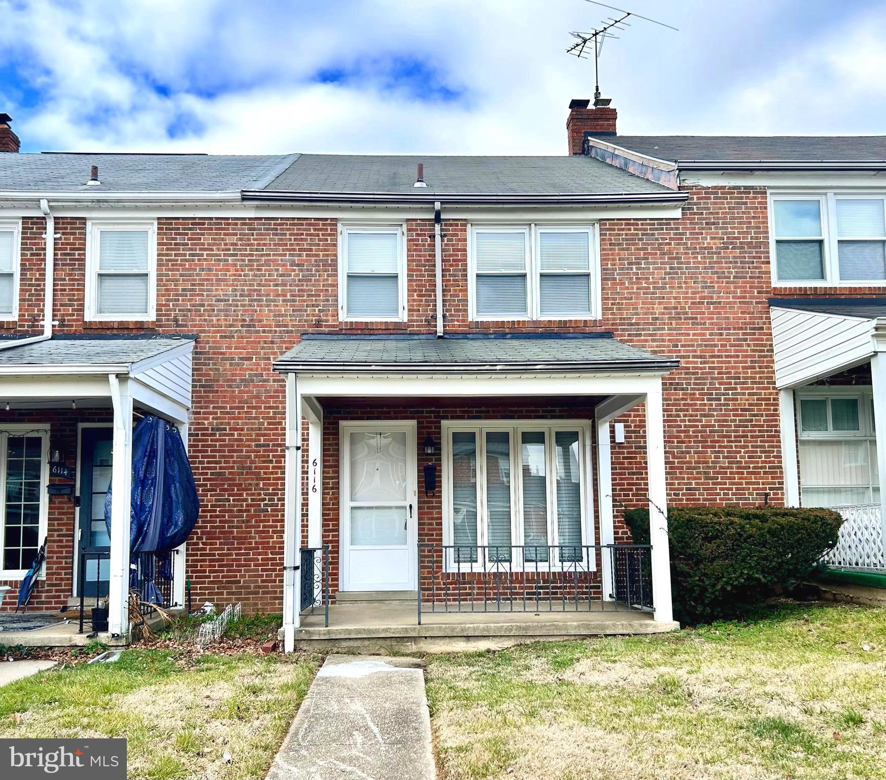 6116 Edlynne Road Baltimore, MD 21239 - Photo 2 of 18 a view of a brick house with large windows and a yard