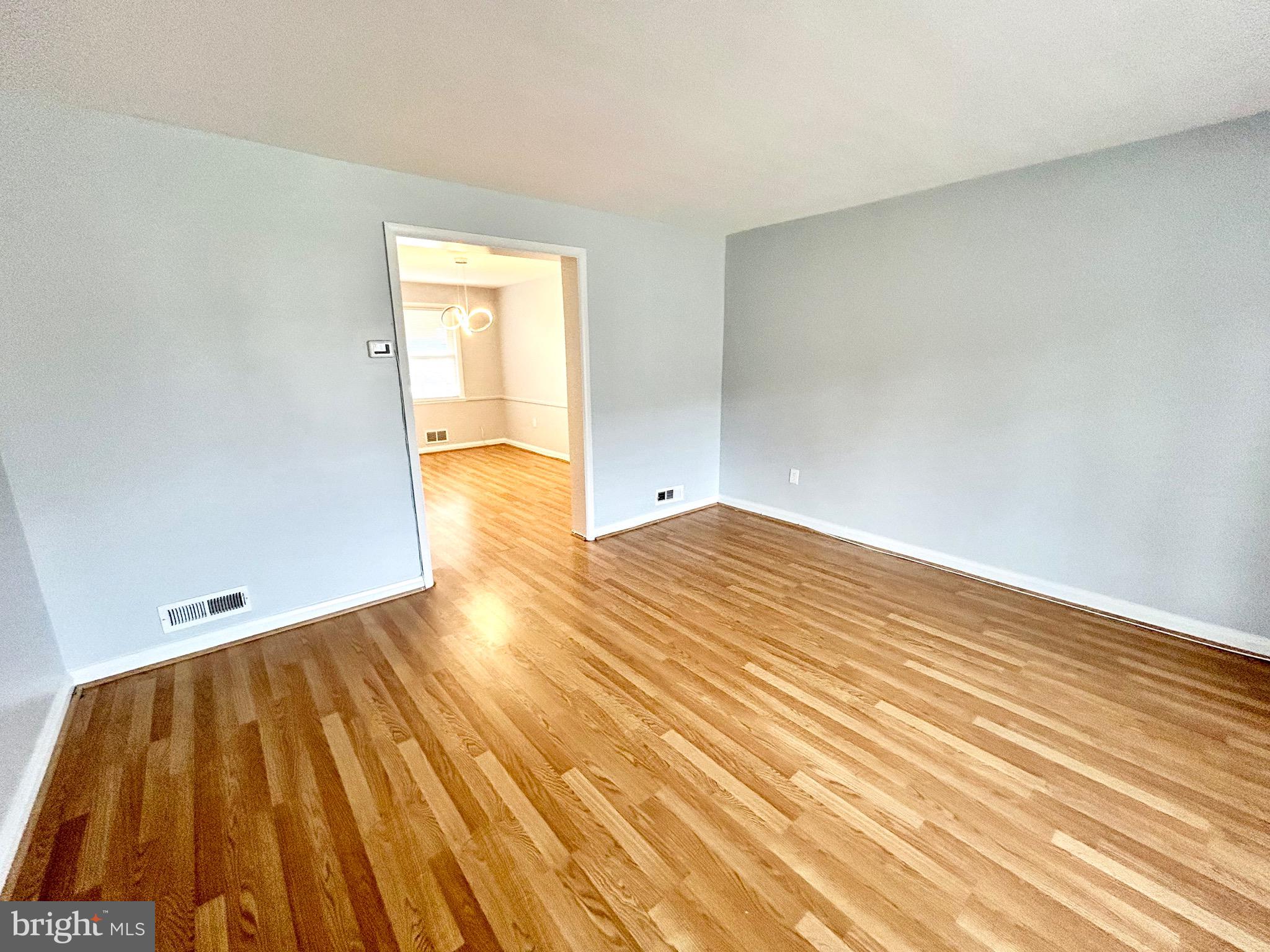 6116 Edlynne Road Baltimore, MD 21239 - Photo 3 of 18 a view of empty room with wooden floor